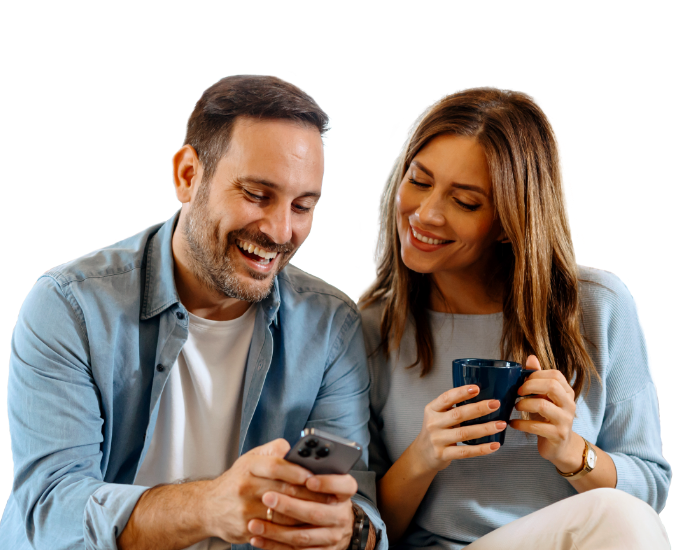 Happy couple enjoying morning coffee and smiling after seeing their paychecks deposited 3 days early.