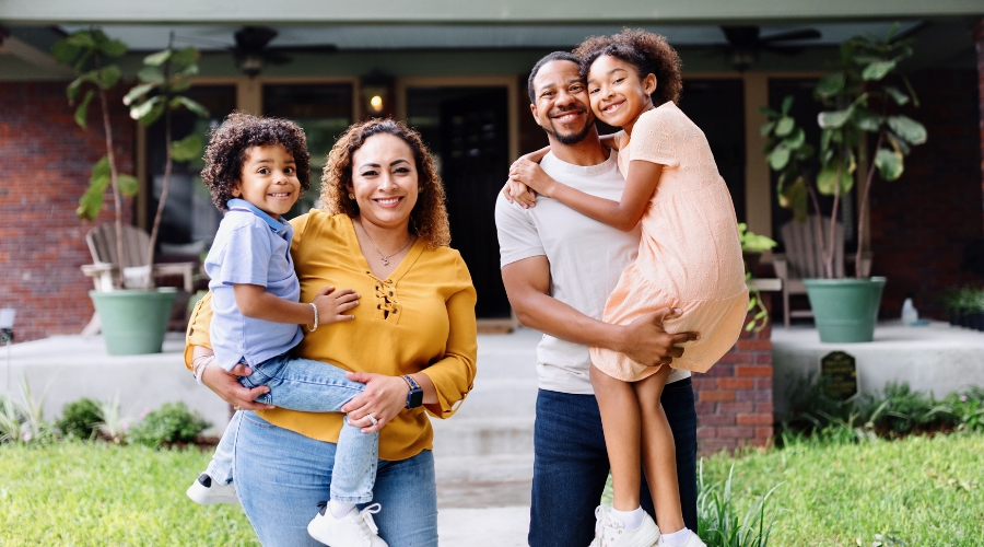 A family standing in front of their new home in North Carolina financed with the Civic first-time homeowners loan.