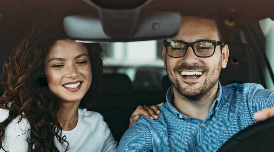 A couple happily celebrating their new car purchase, financed with Civic new auto loan.