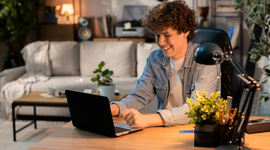 Teenage boy checking his NexGen checking account balance on his laptop. 