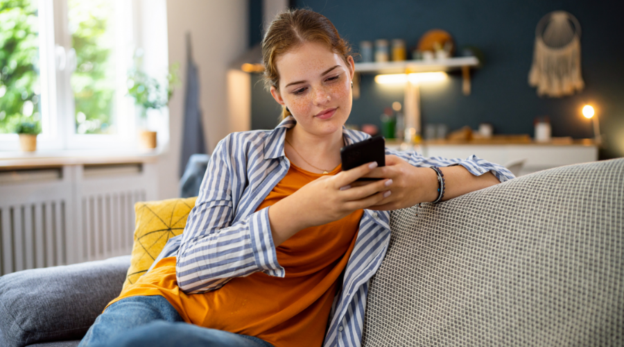 Teenage girl looking at her NextGen Savings account in the Civic app to see if she is hitting her savings goals.