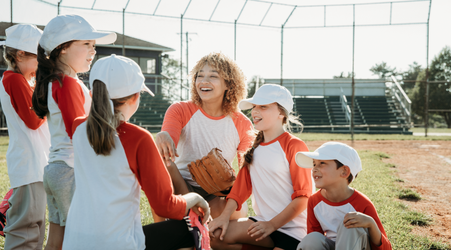 Woman coaching a co-ed Little League baseball team for an NC parks and recreation league.