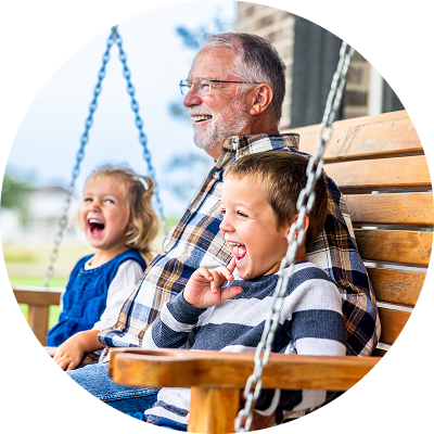 Grandpa with his grandkids swinging on a porch swing.
