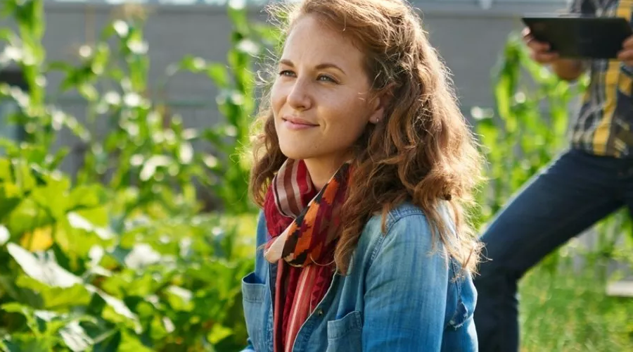 A woman sitting in the community garden, happy she opened a Civic Nonprofit Checking Account to enhance the impact of her nonprofit.