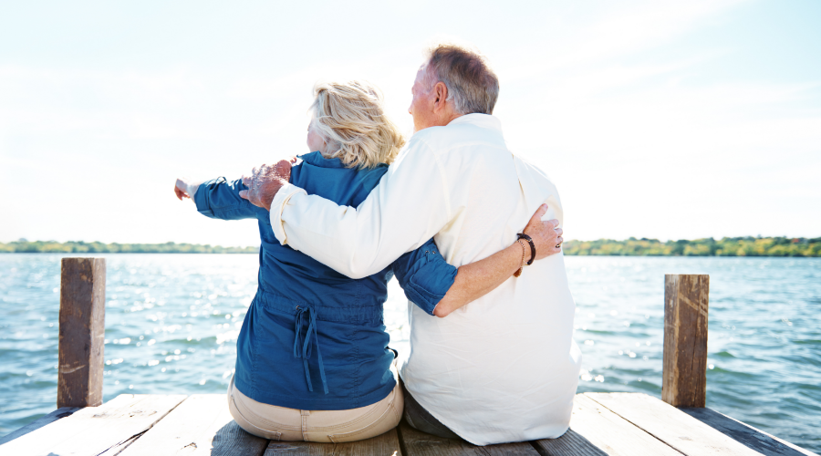 A couple relaxing on a dock, enjoying their retirement, supported by their Civic Roth IRA savings.