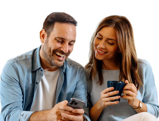 Happy couple enjoying morning coffee and smiling after seeing their paychecks deposited 3 days early.