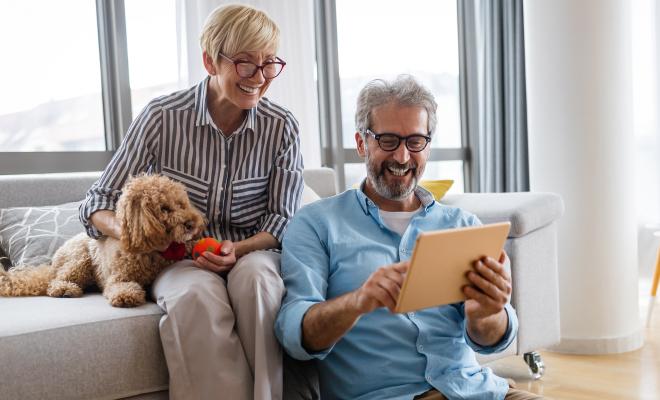 Older couple checking their Civic IRA Certificate growth on their tablet.