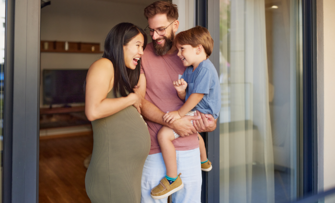 Happy pregnant woman talking to her family while spending their time together on a patio.