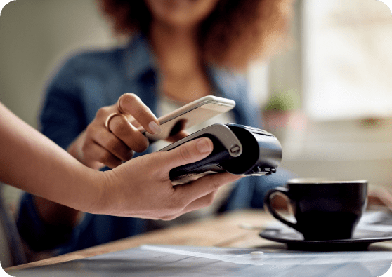 Woman using her digital wallet to pay for morning coffee.