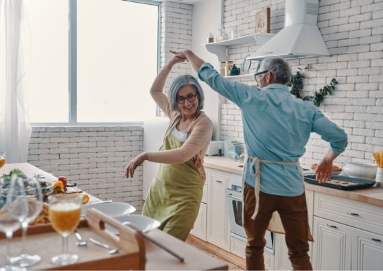Couple dancing in the kitchen, enjoying retirement with a Civic Roth IRA.