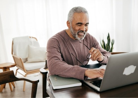 Man sitting at a desk his laptop, applying for a Civic Roth IRA.