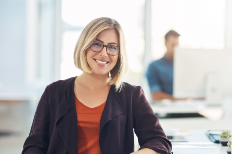 A small business owner in her office with computers and other equipment bought with a Civic Business Term Loan.