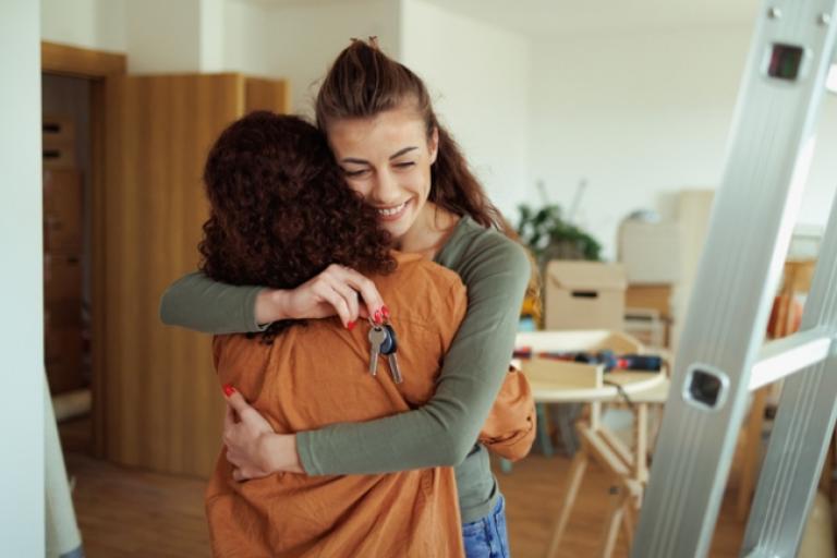 A young woman celebrating being a first-time homeowner thanks to her mortgage loan with Civic Credit Union.