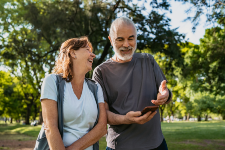 Senior couple smiling while using Civic Credit Union app to earn and spend with their Money Market account.