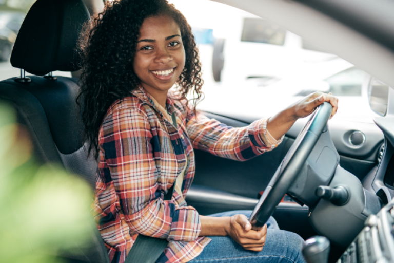 A first-time car owner financed by the Civic auto loan, happily driving off the lot.