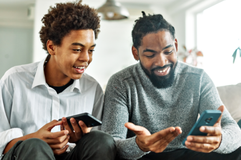 Father teaching his teenage son how to save money using the Civic mobile app and NextGen Savings account.