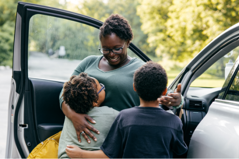 A mother picking up her two kids in her new car, made possible by Civic's auto loan.