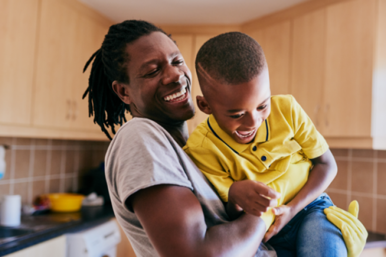  A dad plays with his son, feeling confident and happy knowing his credit score has improved, thanks to Civic's Credit Builder Loan.