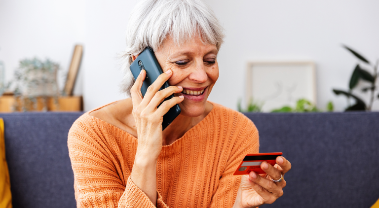 woman on the phone holding a credit card