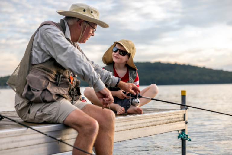 A grandfather fishing with his grandson off the dock at his favorite lake in North Carolina.