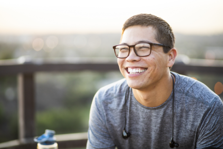 A man sits on a balcony, feeling pleased with his decision to open a Civic Select Savings Account.