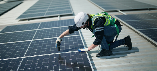 man installing solar panels on the roof