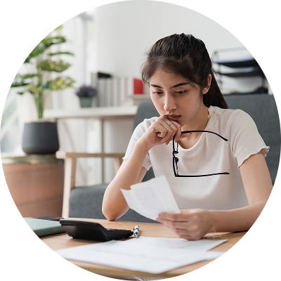 A woman reviewing bills at her table, focused and determined as she makes plans to get out of judgment debt.