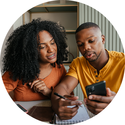 couple sitting at a kitchen table reviewing finances with a calculator and notepad, planning a rainy day fund on a gloomy day.
