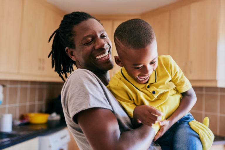 A dad plays with his son, feeling confident and happy knowing his credit score has improved, thanks to Civic's Credit Builder Loan.
